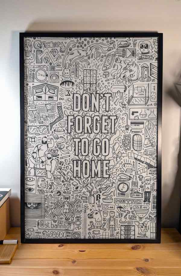 Framed doodle on a desk. A large ‘Don’t forget to go home’ message is written in the center, surrounded by tiny elements inspired by memories from the legendary Berghain club.